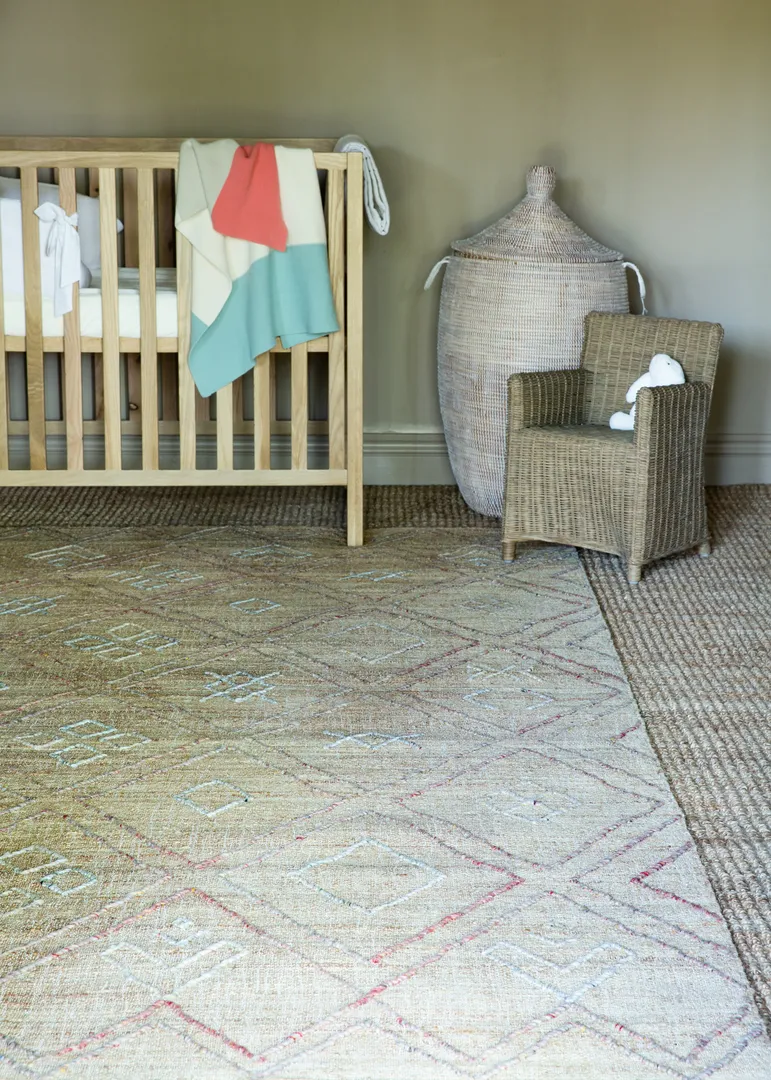 Woven Bliss – a baby crib in a room on a kimberley rug