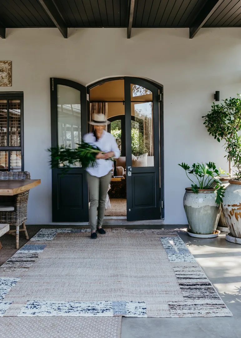 Woven Bliss – flat woven rug outside with person walking on it