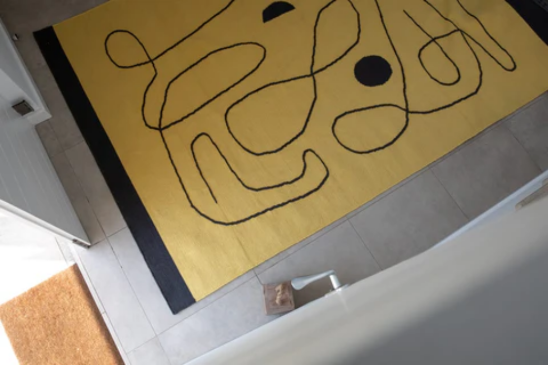 Woven Bliss – Village Citrus rug with black lines on tile floor